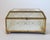 Vintage brass and glass trinket box with floral motif and mirrored bottom. No makers mark. One foot does have damage. It...
