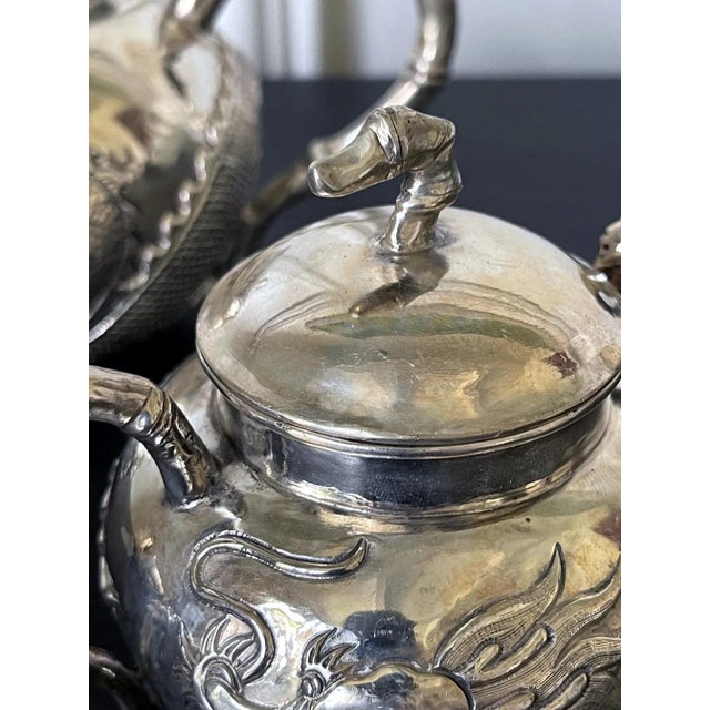 An early set of Chinese export sterling silver tea service circa 1840-70s. The service consists of a lidded tea pot, a...