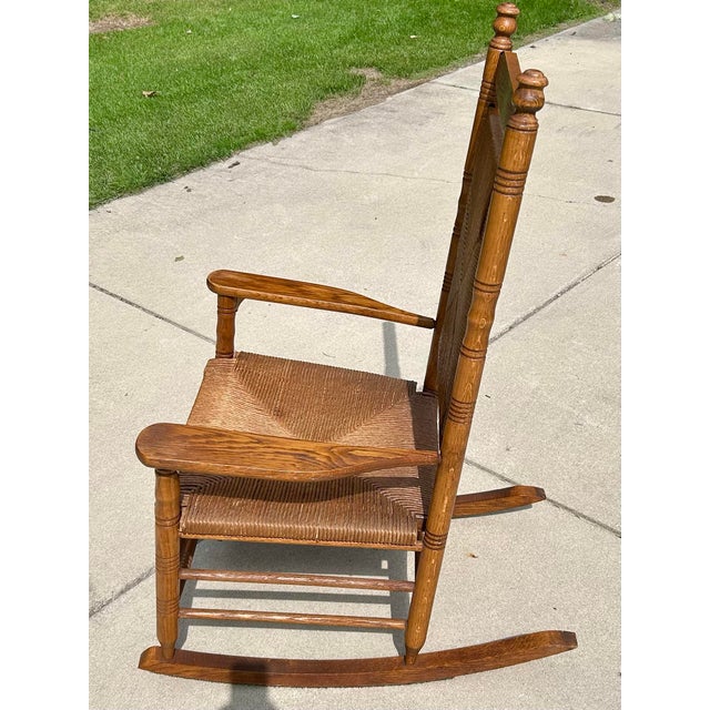 This vintage oak, rocking chair, has a comfortable rush-woven seat and backrest, with an extra wide and deep seat, too! It...