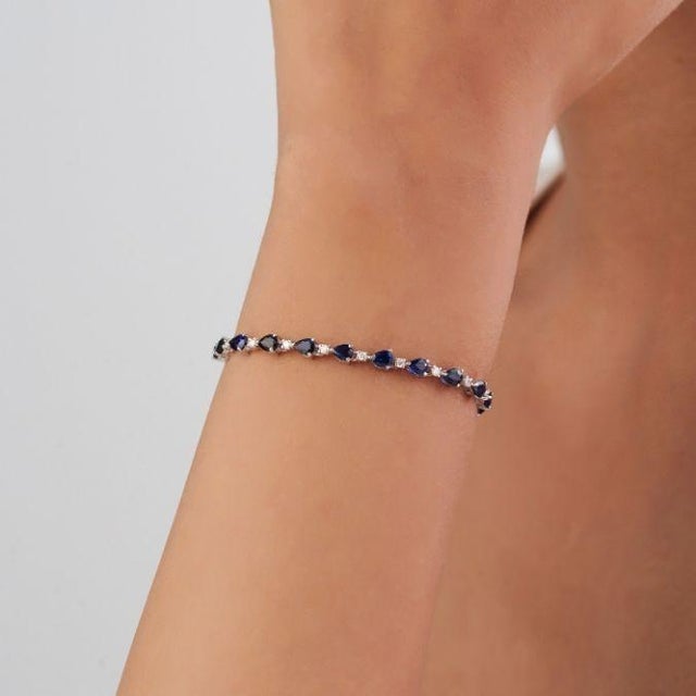 This elegant tennis bracelet features 6.13ct natural blue sapphire, set in 14k white gold. Each sapphire measuring...