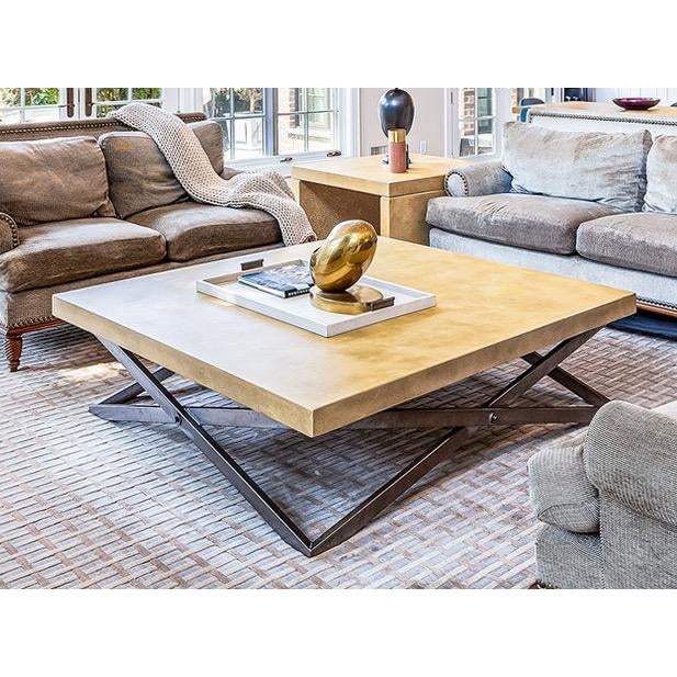 A modern geometric-infused coffee table with a poured, stained and thick square concrete top and blackened steel base with...