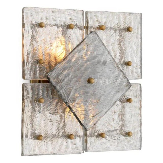Pair of contemporary wall lamp that combines a vintage brass finish with panels of handblown glass in a compact geometric...