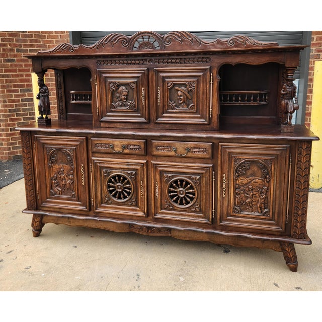 An impressive early 20th-century hand-carved oak sideboard from Brittany, France, featuring richly carved figural and...