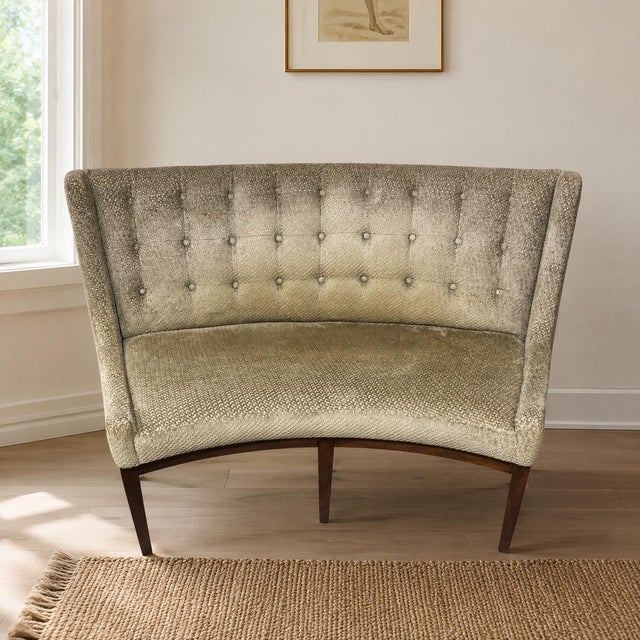 An elegant button-tufted curved sofa designed by Michael Weiss for Vanguard Furniture, showcasing the refined proportions...