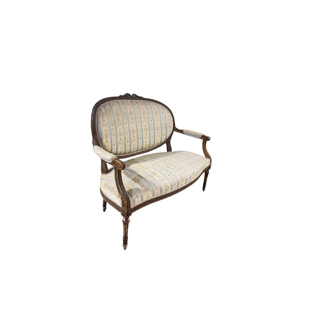 19th Century French Louis XVI walnut settee Canape is truly a timeless classic! Featuring curved oval seatbacks and...