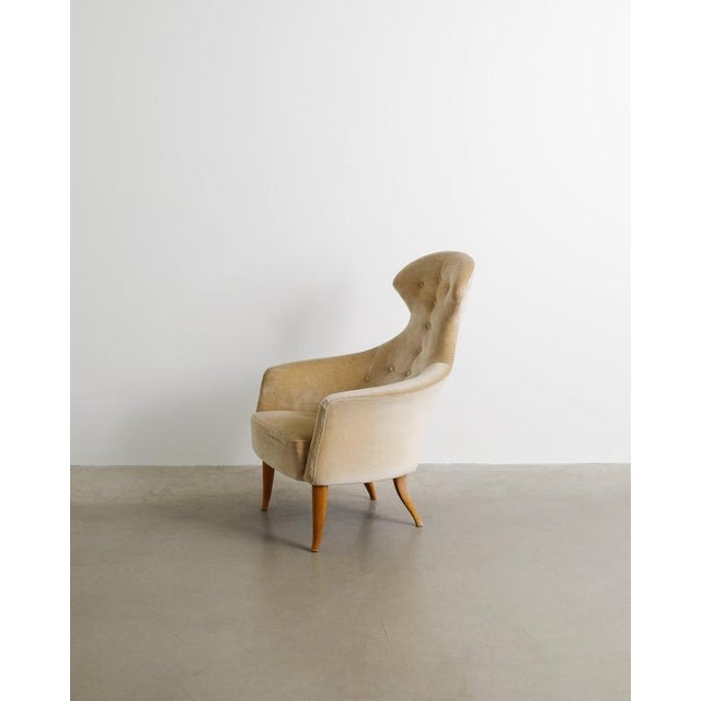 A rare swedish and early mid century sculptural "stora eva" armchair with dark stained beech wooden legs and original...