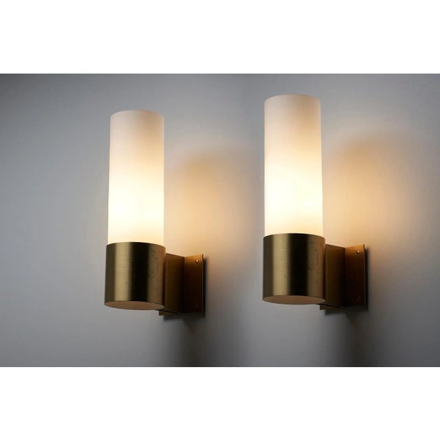 Add a touch of minimalist elegance to your space with the Brass with Glass Wall Sconce by Fog&Mørup, designed by Jorgen Bo...