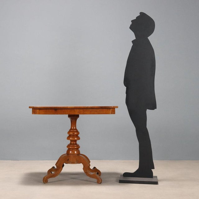 Walnut coffee table. Top with Mercury's chariot inlaid in central maple, and trim in various woods, turned central leg...