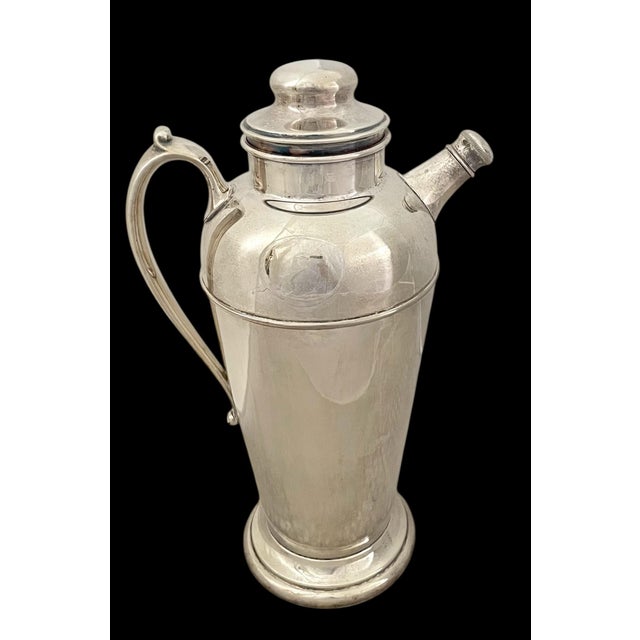 The VTG Crescent Silverware MFG Co. silver plated cocktail shaker is a vintage piece that embodies the Art Deco style...