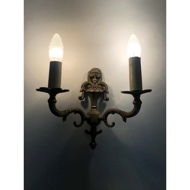 Pair of two-arm gilt bronze wall sconces in the shape of fire pots. Pair of two-arm gilt bronze wall sconces in the shape...