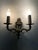 Pair of two-arm gilt bronze wall sconces in the shape of fire pots. Pair of two-arm gilt bronze wall sconces in the shape...
