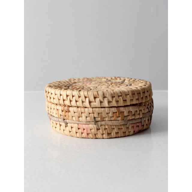 This vintage woven grass basket box features delicate pale pink and light blue accents and a flush-fitting lid. Perfect...