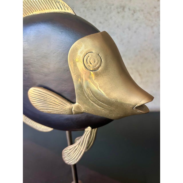 Sculptural vintage 1970s decorative fish crafted from dark finished wood with contrasting brass fins, tail and facial...