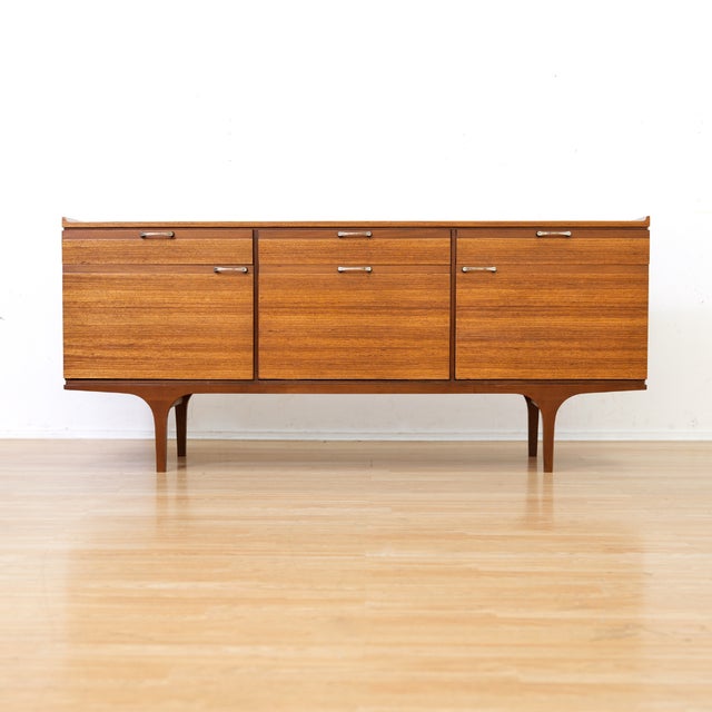 This mid-century credenza was produced by Meredew of Letchworth in Hertfordshire England. Made during the 1960s, with...
