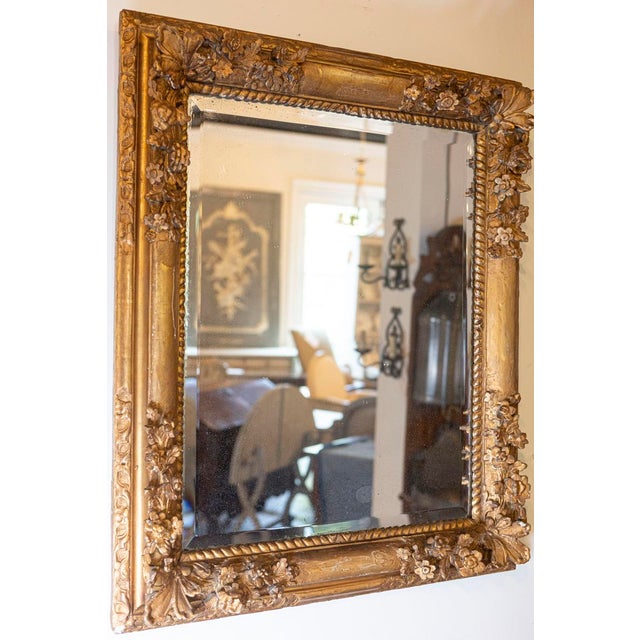 This French late 18th century Régence style carved mirror features an exquisite rectangular giltwood frame adorned along...