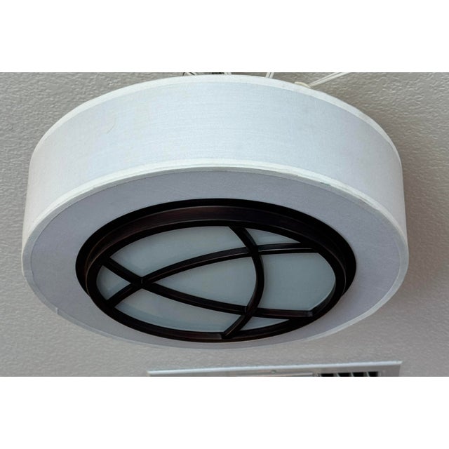 Design Plus Gallery presents an Orbit Drum Flush Mount Ceiling Light. The circular fixture has an ivory fabric drum shade...