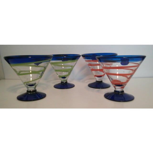 These colorful cocktail glasses are collectible Royal Caribbean Kosta Boda hand-blown martini glasses, featuring a cobalt...