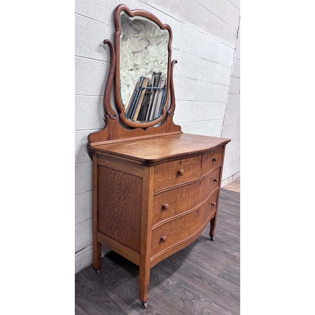This is a gorgeous antique Victorian quarter-sawn tiger oak serpentine dresser with beveled swivel mirror, circa early...