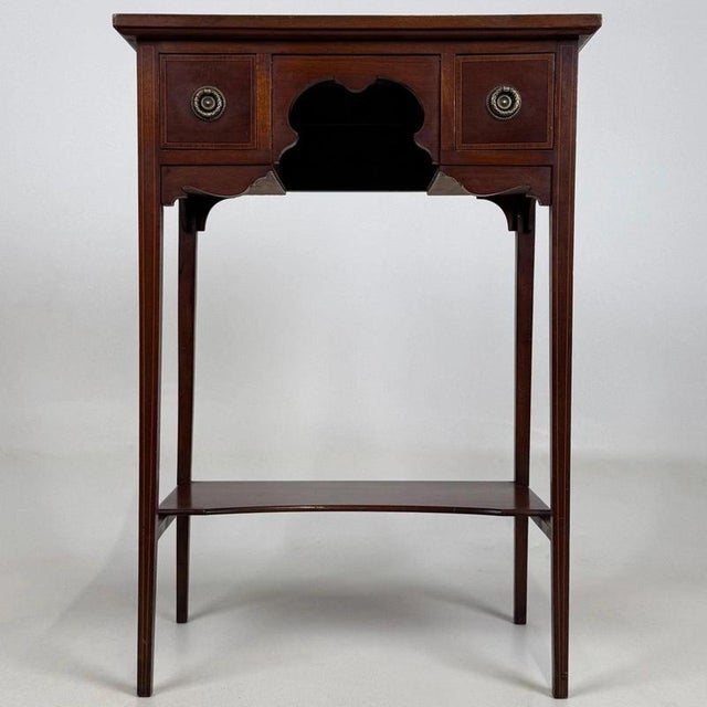 A beautifully crafted early 20th-century English Edwardian side table, finely constructed in mahogany and distinguished by...