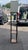Contemporary dark wood floor lamp featuring three built-in display shelves and a clean white fabric shade. A great space-...