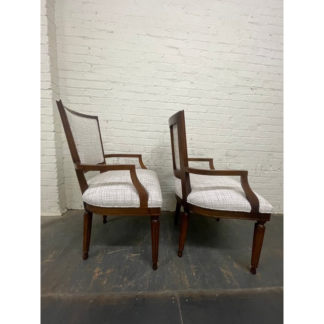 A pair of early 21st century walnut armchairs with upholstered seats and backrests in a heavy woven fabric with tapered...