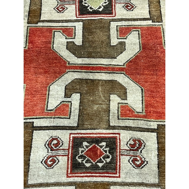 Vintage Turkish rug, hand-knotted in Turkey from 100% wool. Measuring 3’8” x 7’8”, the rug features a bold geometric...