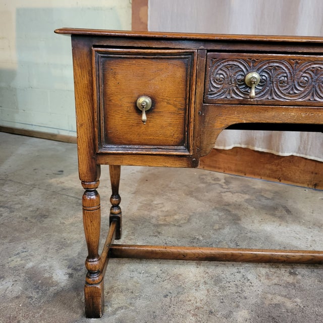 English Oak Lady's Desk on Turned Legs With H Stretcher Base and Tear Drop Handles with a carved center drawer.