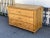 This spacious Central European three drawer chest is largely bereft of any decoration except for an ogee crown molding...