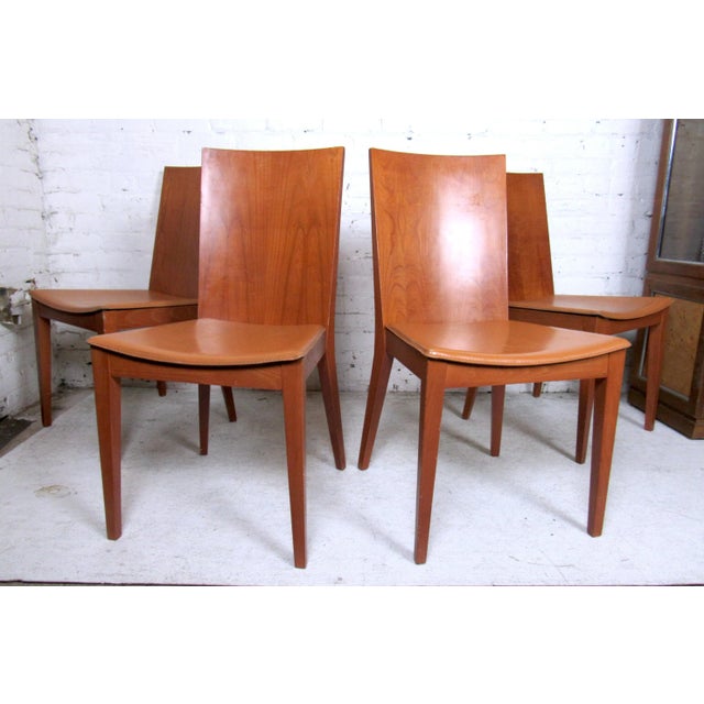Vintage modern set of four dining chairs featuring a sleek curved back and vinyl covered seats. Dimensions: H 34.5 in. x W...