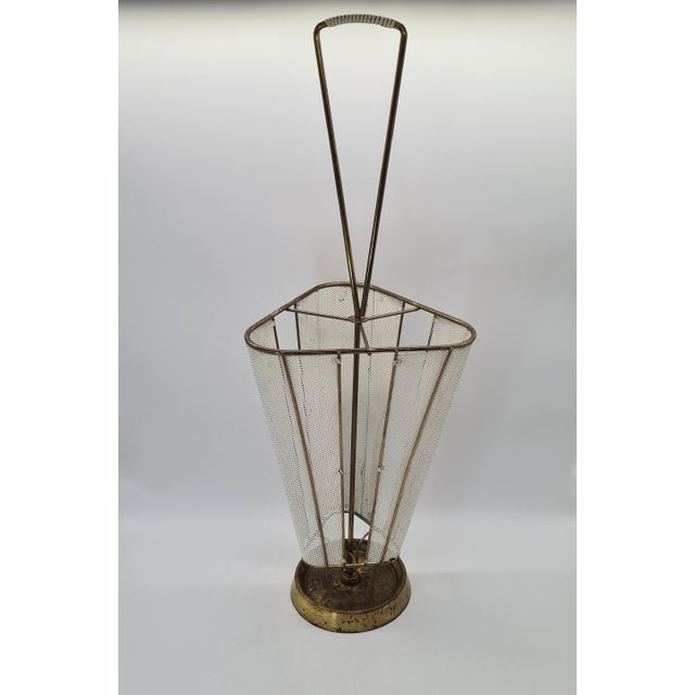 An elegant, original umbrella stand from the mid-20th century, made of perforated sheet metal, metal rods, and brass...