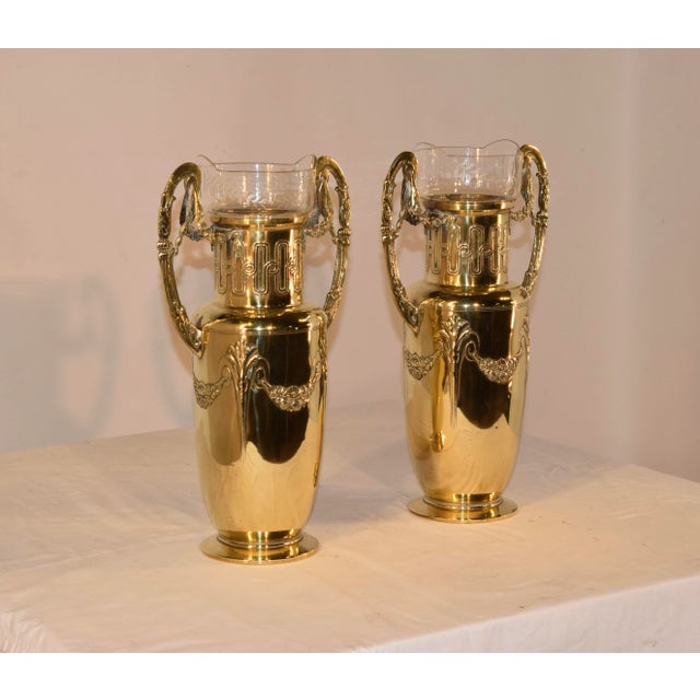 Pair of 19th century hand cast brass vases with elegantly shaped handles which have floral swags and columns, connected to...