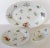Set includes a large platter, vegetable side dish and a raised cake plate each decorated with scattered spring flowers....