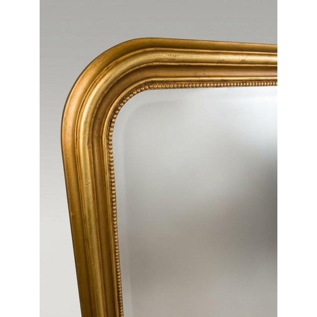 A beautiful French panel mirror of large proportions. Crafted with a richly gilded frame featuring a classic arched top...