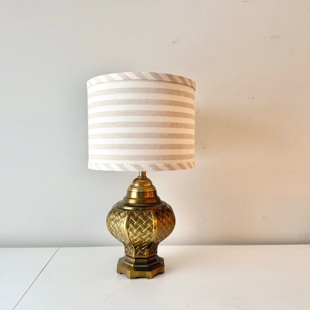 Vintage brass rattan basketweave ginger jar style table lamp paired with striped barrel lampshade.