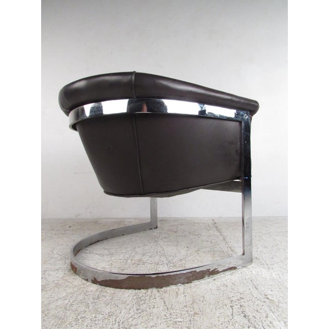 This unique barrel back chair features rich dark brown leather with a chrome finish cantilever base in the style of Milo...