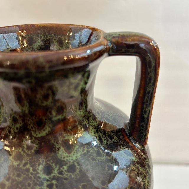 Tall speckled ceramic urn vase. The base color is brown and it has flecks and speckles in varying shades of greens. Great...