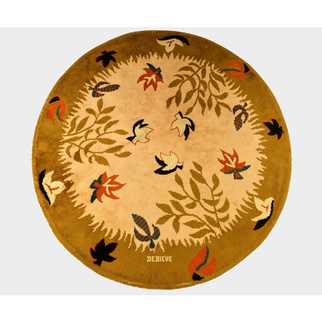 Hand-knotted in wool, this 9x9 vintage French circular rug by Robert Debiève (1926–1994) is a charming example of mid-...