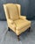 This tan leather wingback arm chair features classic rolled arms, a tall back, and Queen Anne style cabriole legs....