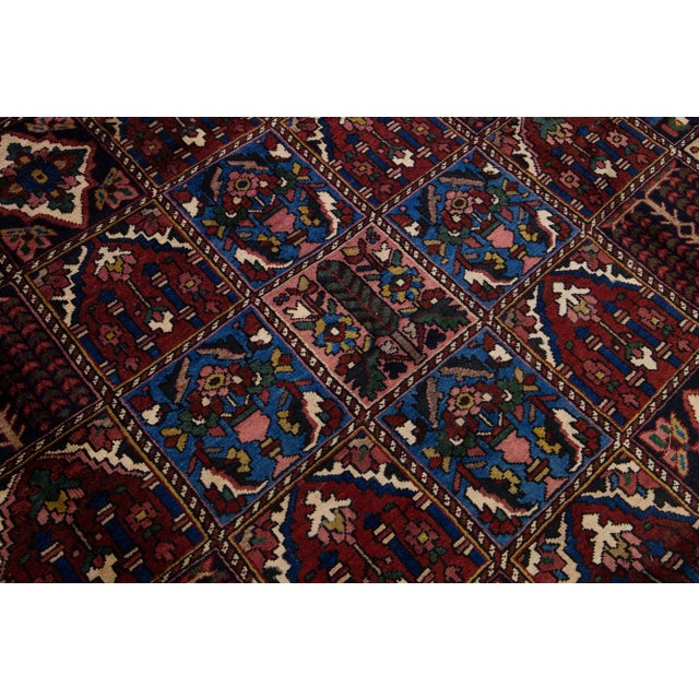 Beautiful Antique Bakhtiari hand-knotted wool rug with a burgundy color field. This Persian piece has an all-over classic...