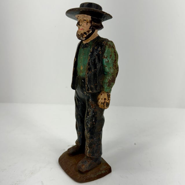 Pennsylvania Amish Man Sculpture as a Cast Iron Door Stopper, Early 20th Century. The sculpture is hand-painted in blue...