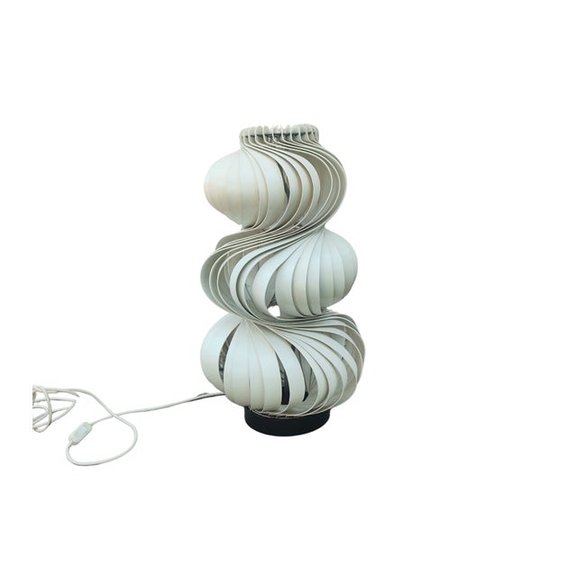 "Medusa" metal table lamp The lamp body is made of white lacquer with wavy metal strips, on a black lacquered circular...