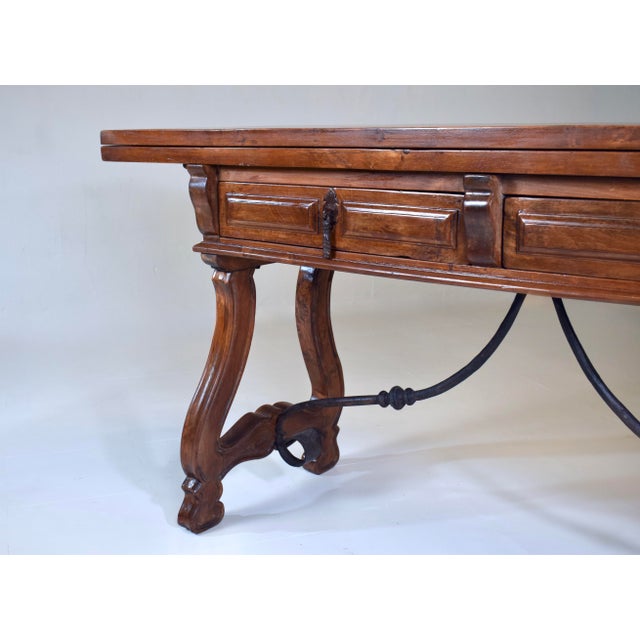 Chestnut 20th Century Spanish Fold Out Dining and Console Table With Iron Stretcher and Two Drawers For Sale - Image 8 of 17
