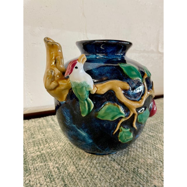 Vintage majolica-style high relief bird vase with dominant colors of deep royal blue, cherry red, green, tan, and white.