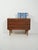 1950s–1960s chest of drawers with three drawers, recessed double-loop handles, and turned legs. Laminate with a rosewood-...