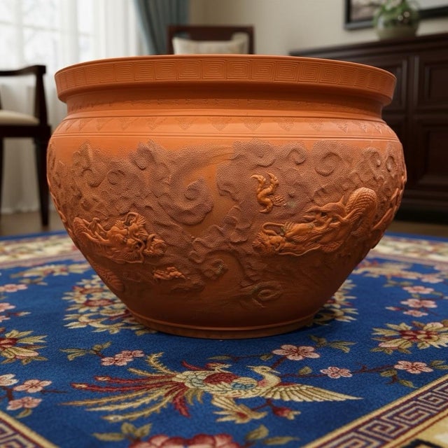 A large Terracotta Jardinière Planter depicts Chinese Foo Dragons moving in and out of clouds-stippled texture. Designed...
