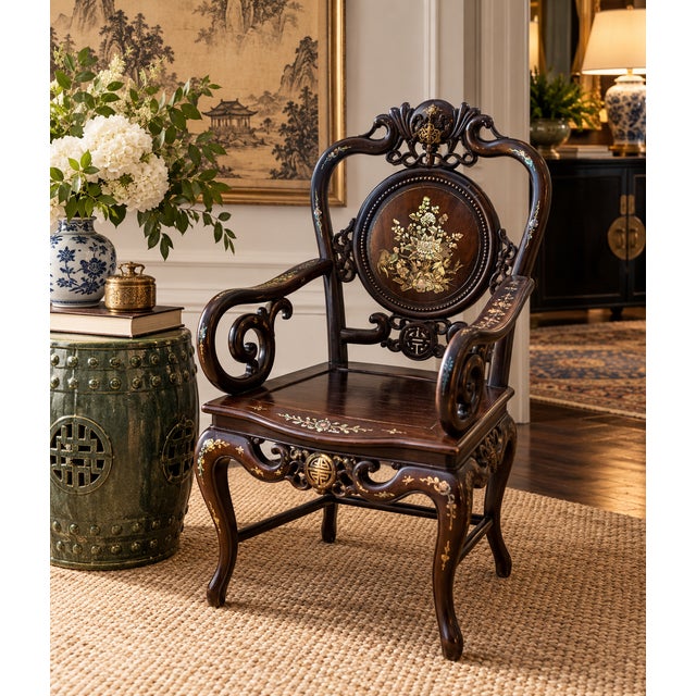 A striking vintage Chinese armchair crafted in a richly toned dark hardwood and extensively decorated with mother-of-pearl...