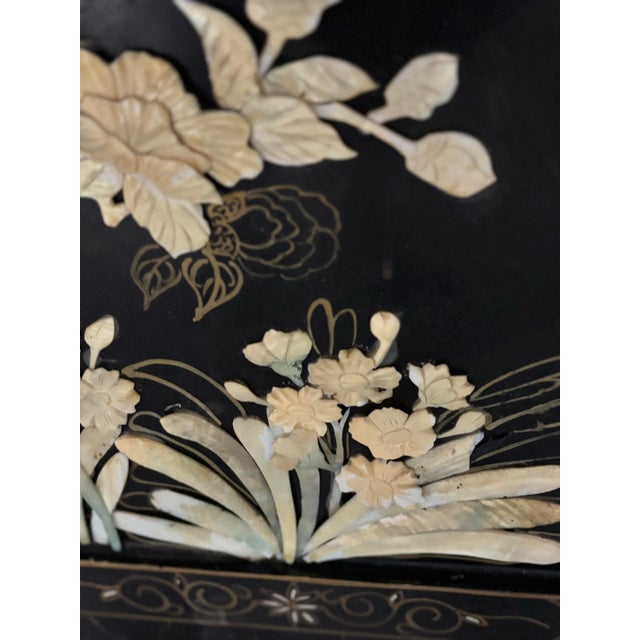 Stunning, three-dimensional mother-of-pearl, hand carved Pandas inlaid on black ebony lacquer panels with brass feet. A...