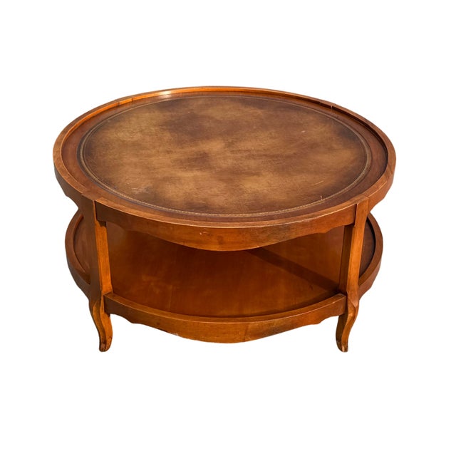 French Provincial Round Coffee Table with Gold-Embossed Inset & Cabriole Legs Description An elegant vintage round coffee...