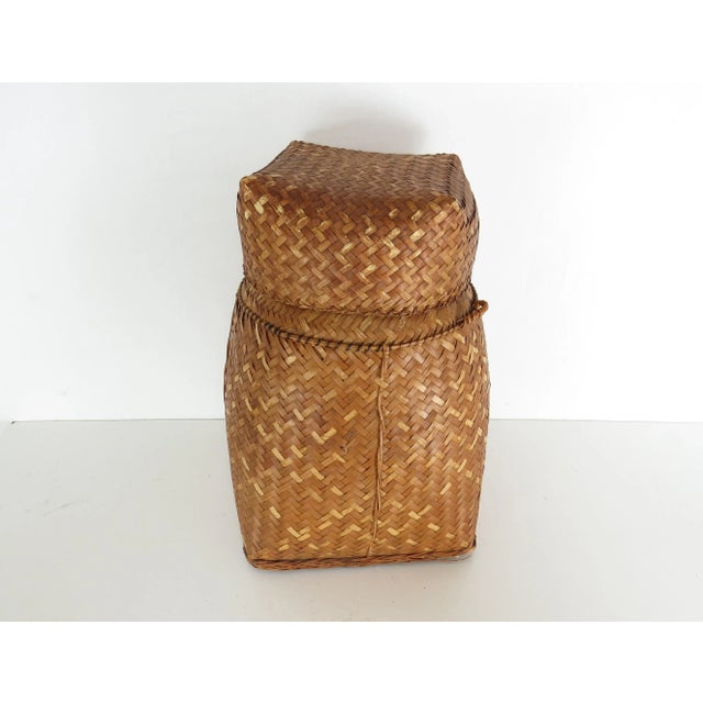 Vintage woven rattan rice carrying basket with fitted removable lid. Basket is square at the bottom and tapers up to a...