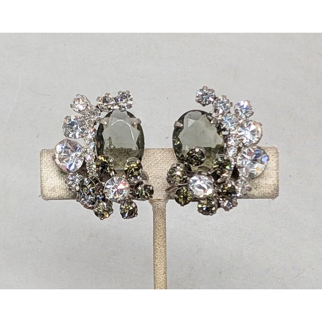 1960s rhodium plated prong set oval unfoiled open backed faux-black diamond with a "flower" at the bottom comprised of a...